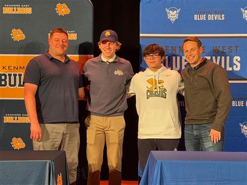 two student athletes and their coaches pose for a picture at their signing day ceremony.